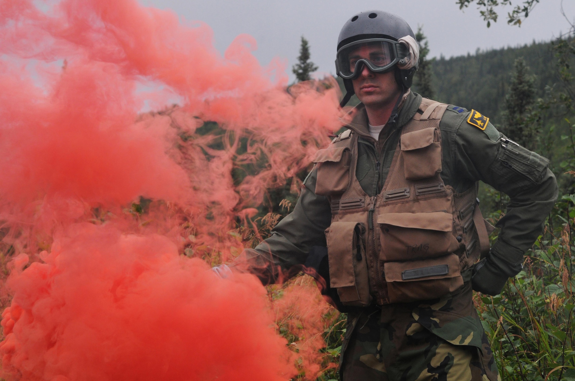 U.S. Air Force Capt. Austin Cox, a pilot with the Minnesota Air National Guard's 148th Fighter Wing, holds a smoke flare to identify his location during an isolated personnel recovery exercise Aug. 13, 2015, at Eielson Air Force Base, Alaska, while participating in RED FLAG-Alaska (RF-A) 15-3.  RF-A is a Pacific Air Forces commander-directed field training exercise for U.S. and partner nation forces, providing combined offensive counter-air, interdiction, close air support and large force employment training in a simulated combat environment.  (U.S. Air Force photo by Master Sgt. Ralph Kapustka/Released)