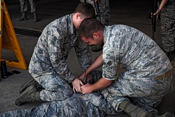 U.S. Air Force Senior Airmen Cody Murphy and William Garrett, 51st Medical Group security team members, detain a simulated uncooperative person during a training class on Osan Air Base, Republic of Korea, Aug. 18, 2015. The security team spent the day training 51st MDG members on proper security protocols and use of force prior to an impending exercise. (U.S. Air Force photo by Tech. Sgt. Travis Edwards/Released) 