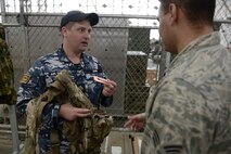 Royal Australian Air Force Leading Aircraftsman Mark Dunn, 42nd Wing, 2nd Squadron aeronautical life support fitter, explains an air warrior ensemble to U.S. Air Force Senior Airman Kenny Batallas and Airman 1st Class Jonathon Archer, both aircraft flight equipment technicians with the 374th Operations Support Squadron, during Red Flag-Alaska at Joint Base Elmendorf-Richardson, Alaska, Aug. 18, 2015. Dunn, Batallas and Archer, having the same jobs, but in different Air Forces, shared information about the similarities and differences of equipment and work. (U.S. Air Force photo by Staff Sgt. Cody H. Ramirez/Released)