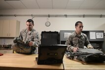 U.S. Air Force Senior Airman Kenny Batallas and Airman 1st Class Jonathon Archer, both aircrew flight equipment technicians with the 374th Operations Support Squadron, inspect parachutes for wear and tear during Red Flag-Alaska at Joint Base Elmendorf-Richardson, Alaska, Aug. 18, 2015. The AFE members joined the 36th Airlift Squadron during Red Flag-Alaska, servicing the aircrew safety equipment such as harnesses, helmets, masks and parachutes. (U.S. Air Force photo by Staff Sgt. Cody H. Ramirez/Released)