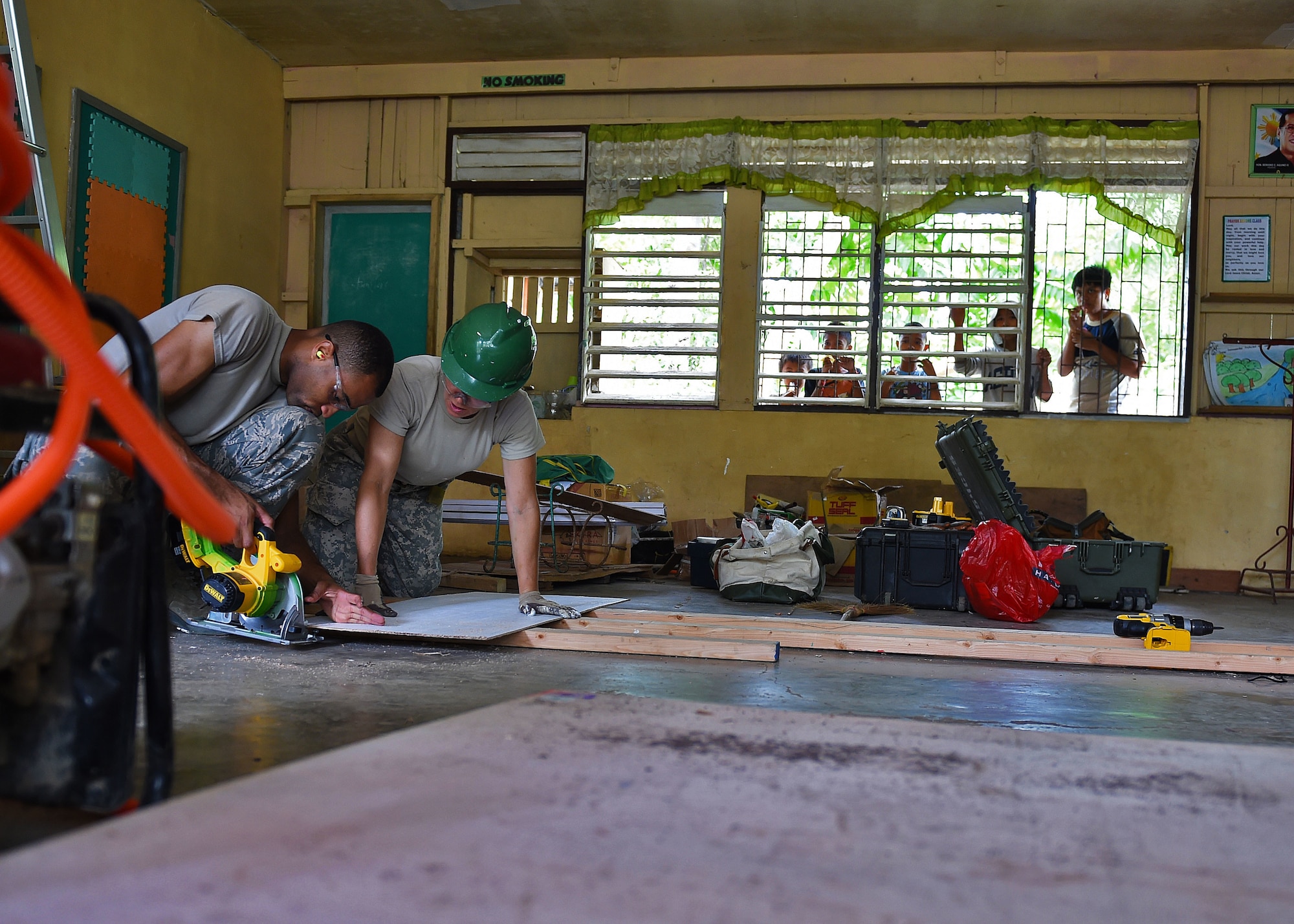 Working as members of a engineering civic action team for Pacific Angel Philippines, Airmen 1st Class Bryan Wallace, from the 354th Civil Engineering Squadron, Eielson Air Force Base, Alaska, (left) and Army Staff Sgt. Andrea White, from the 84th Engineer Battalion, 130th Engineer Brigade, Schofield Barracks, Hawaii, work to trim a piece of wood to be installed on the ceiling of Dao Elementary in the Bohol Provence, Philippines, Aug. 20, 2015. Dao Elementary is one of six schools repaired by the U.S. and its Indo-Asia-Pacific allies during Pacific Angel Philippines. Efforts undertaken during Pacific Angel help multilateral militaries in the Pacific improve and build relationships across a wide spectrum of civic operations, which bolsters each nation’s capacity to respond and support future humanitarian assistance and disaster relief operations. (U.S. Air Force photo by Tech. Sgt. Aaron Oelrich/Released)