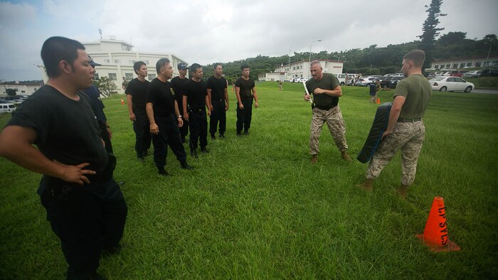 Staff Sgt. Paul J. Delekto demonstrates baton strikes during nonlethal weapons and level one oleoresin capsicum spray training aboard Camp Foster Aug. 14. According to Delekto, the security augmentation force instructor and staff noncommissioned officer with mobile training team, Provost Marshal’s Office, Marine Corps Base Camp Smedley D. Butler, Marine Corps Installations Pacific, nonlethal weapons training includes all weapons and techniques that are not inherently deadly, such as batons, defensive tactics, pepper-based spray, and mechanical-advantage control holds. 