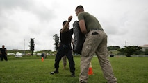 A Japanese security guard executes a knee strike during nonlethal weapons and level one oleoresin capsicum spray training aboard Camp Foster, Okinawa, Japan, Aug. 14. According to Delekto, the security augmentation force instructor and staff noncommissioned officer with mobile training team, Provost Marshal’s Office, Marine Corps Base Camp Smedley D. Butler, Marine Corps Installations Pacific, nonlethal weapons training includes all weapons and techniques that are not inherently deadly, such as batons, defensive tactics, pepper-based spray, and mechanical-advantage control holds. 