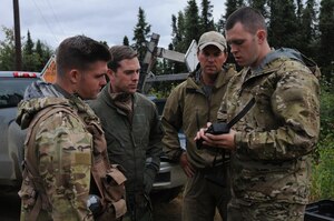U.S. Air Force survival, evasion, resistance and escape specialists Senior Airman Robert Bowler from the Alaska Air National Guard's 212th Rescue Squadron and Staff Sgt. Levi Wood, from the 353rd Combat Training Squadron at Eielson Air Force Base, Alaska, discuss radio procedures with Capt. Skyler Villers, a pilot from the 36th Fighter Squadron, Republic of Korea, and Capt. Austin Cox, a Minnesota Air National Guard pilot with the 148th Fighter Wing, during an isolated personnel recovery exercise Aug. 13, 2015, at Eieslon AFB as part of RED FLAG-Alaska (RF-A) 15-3.  RF-A is a Pacific Air Forces commander-directed field training exercise for U.S. and partner nation forces, providing combined offensive counter-air, interdiction, close air support and large force employment training in a simulated combat environment.  (U.S. Air Force photo by Master Sgt. Ralph Kapustka/Released)