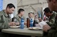 Senior Airman Kenny Batallas, 374th Operations Support Squadron aircraft flight equipment technician, samples authentic Thai food while talking with members of the Royal Thai Air Force at Red Flag-Alaska at Joint Base Elmendorf-Richardson, Alaska, Aug. 18, 2015. RED FLAG-Alaska offers participants a chance to build cultural competence and relationships with each other during an exercise environment, aimed at improving efficiency and familiarity between partner nations in the case of real-world contingencies. (U.S. Air Force photo by Staff Sgt. Cody H. Ramirez/Released)