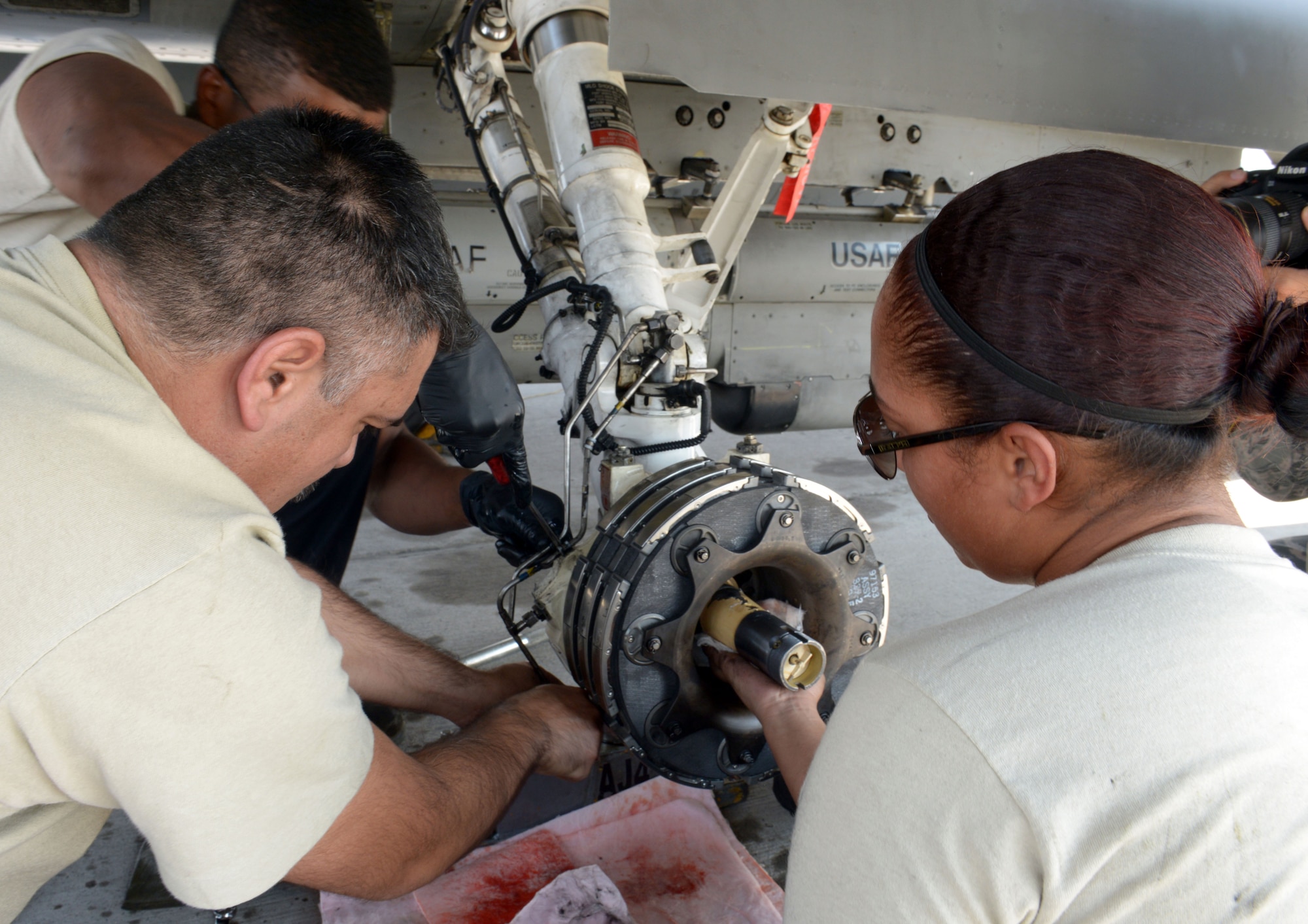 Maintainers assigned to the 20th Aircraft Maintanence Squadron, Shaw Air Force Base, S.C., drain hydraulic fluid from an F-16 Fighting Falcon during Red Flag 15-4 at Nellis AFB, Nev., Aug. 19, 2015. The maintainers drained the hydraulic fluid so they could replace a landing gear tire on the aircraft. (U.S. Air Force photo by Airman 1st Class Rachel Loftis)