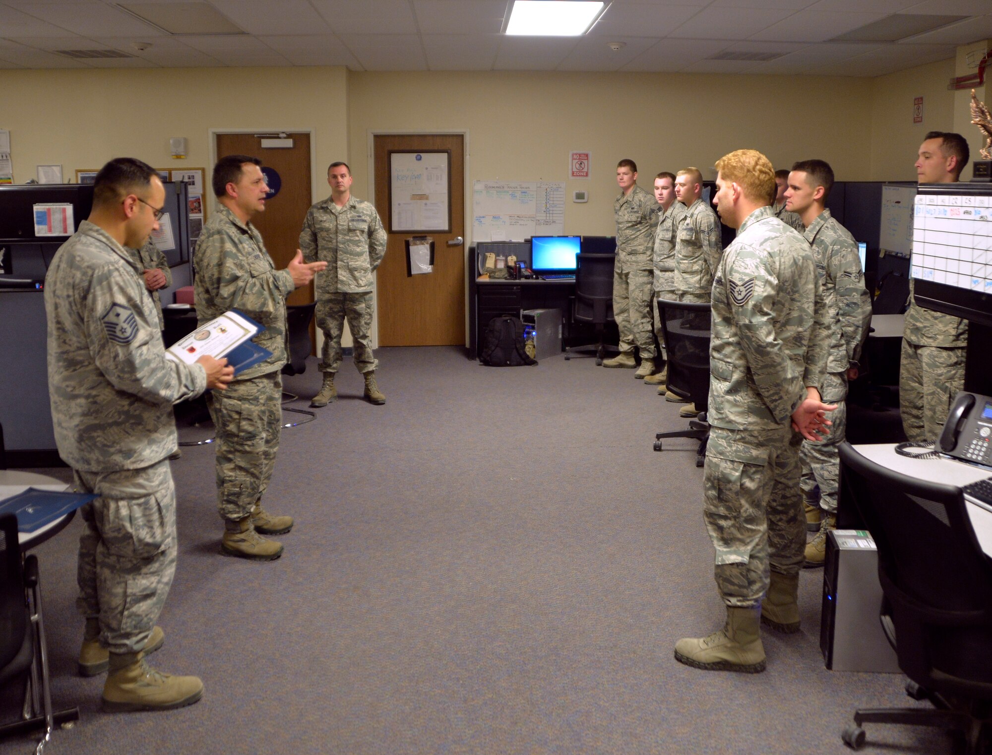 Maj. Raymond Chester, 432nd Aircraft Communications Maintenance Squadron commander, discusses current maintenance operation with the Airmen of the 432nd ACMS during a shift change meeting Aug. 19, 2015, at Creech Air Force Base, Nevada. The 432nd ACMS is responsible for maintaining all the communications equipment needed to fly both the MQ-1 Predator and MQ-9 Reaper remotely piloted aircraft. (U.S. Air Force photo by Airman 1st Class Christian Clausen/Released)