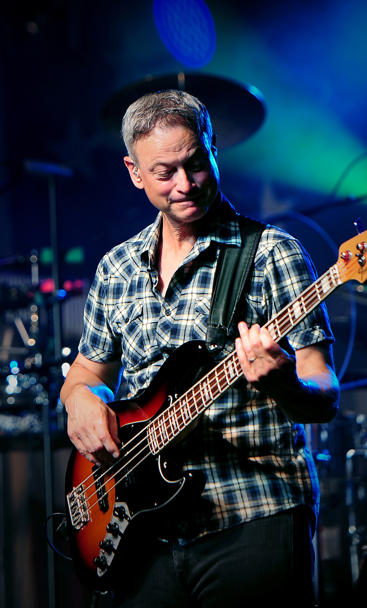 Gary Sinise, musician, founder of the Gary Sinise foundation and actor, plays lead guitar as the Lt. Dan Band performs at Whiteman Air Force Base, Mo. Aug. 14, 2015. Sinise and the Lt. Dan Band travel to various military installations to perform concerts in hopes to boost morale of service members. (U.S. Air Force photo by Airman 1st Class Jovan Banks/Released)
