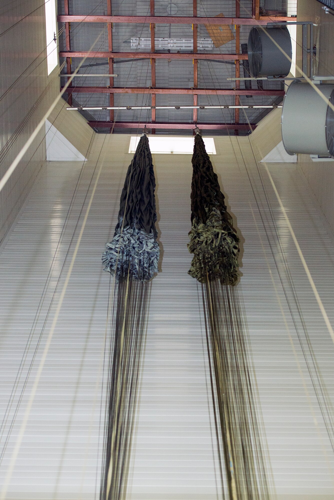 Two G-12 echo parachutes hang at the 347th Operations Support Squadron Aerial Delivery shop Aug. 19, 2015, at Moody Air Force Base, Ga. During airdrop training, parachutes accumulate ground moisture and are hung to prevent damage and release lingering debris. (U.S. Air Force photo by Airman 1st Class Greg Nash/Released)