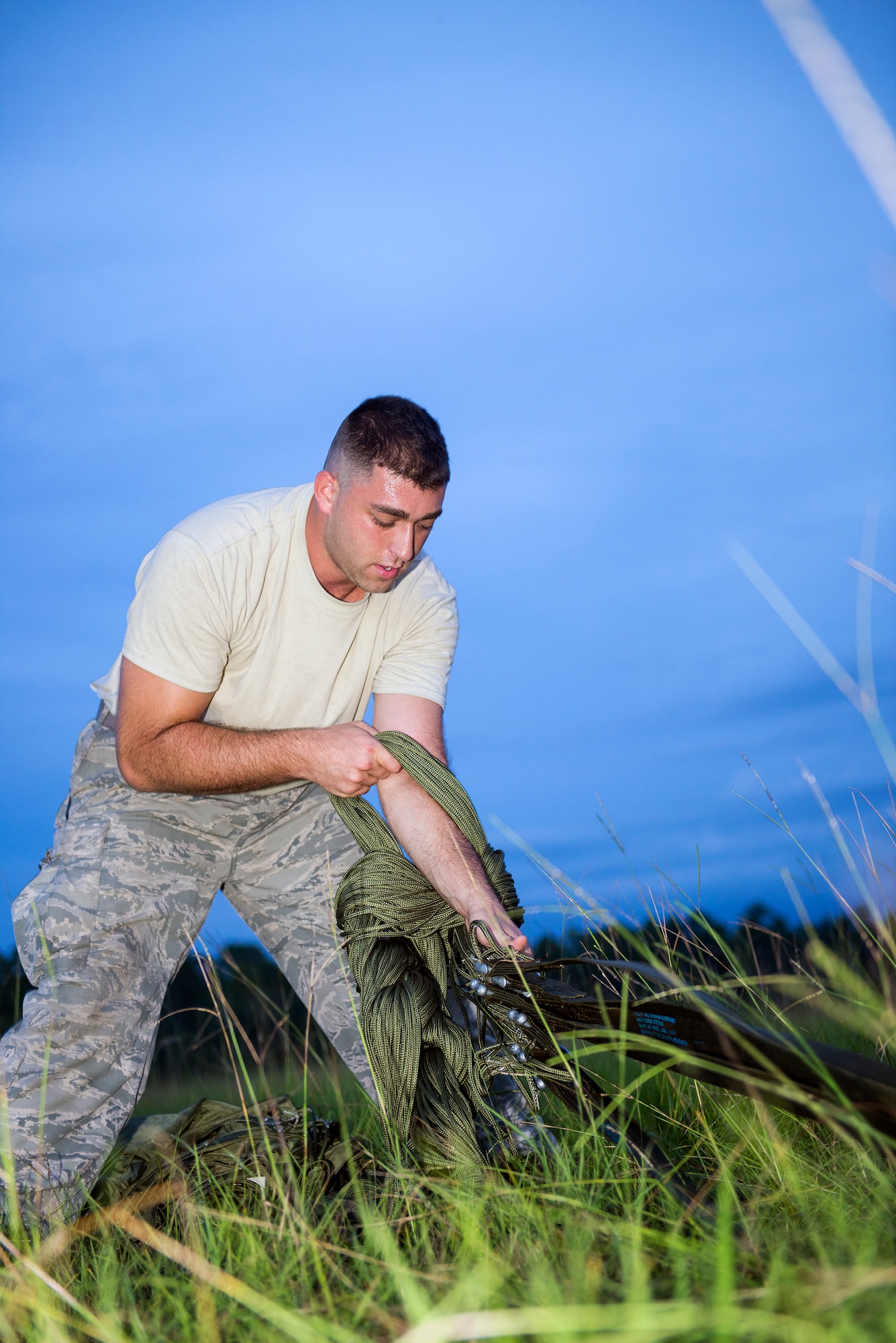 U.S. Air Force Staff Sgt. Michael Mendes, 347th Operations Support Squadron aerial delivery air transportation and loadmaster parachute rigger, connects suspension lines of a G-12 echo parachute during airdrop training Aug. 18, 2015, at Moody Air Force Base, Ga. Air transportation and loadmaster parachute riggers go to Fort Lee, Va. for the Airdrop Specialist Course training to learn parachute packing, container deliver systems, container rigging, and airdrop inspection requirements. (U.S. Air Force photo by Airman 1st Class Greg Nash/Released)