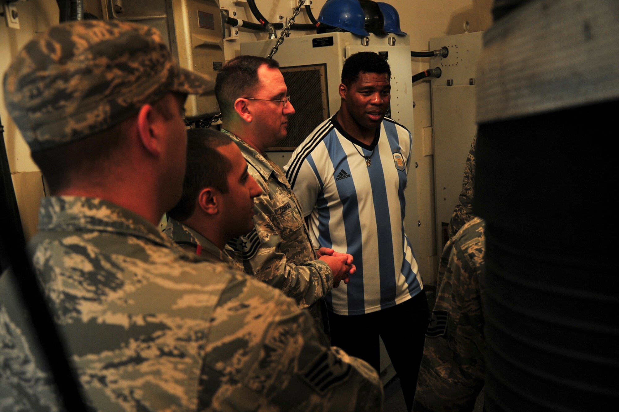 Herschel Walker receives a breakdown of the inside of a missile trainer during his visit to Minot Air Force Base, N.D., Aug. 19, 2015. Walker visited the base to share his message of resiliency and how he overcame his hardships to be the man he is today. Walker is a retired professional football player and while at the University of Georgia, was awarded the Heisman Trophy in 1982.  (U.S. Air Force photo/Staff Sgt. Malia Jenkins)