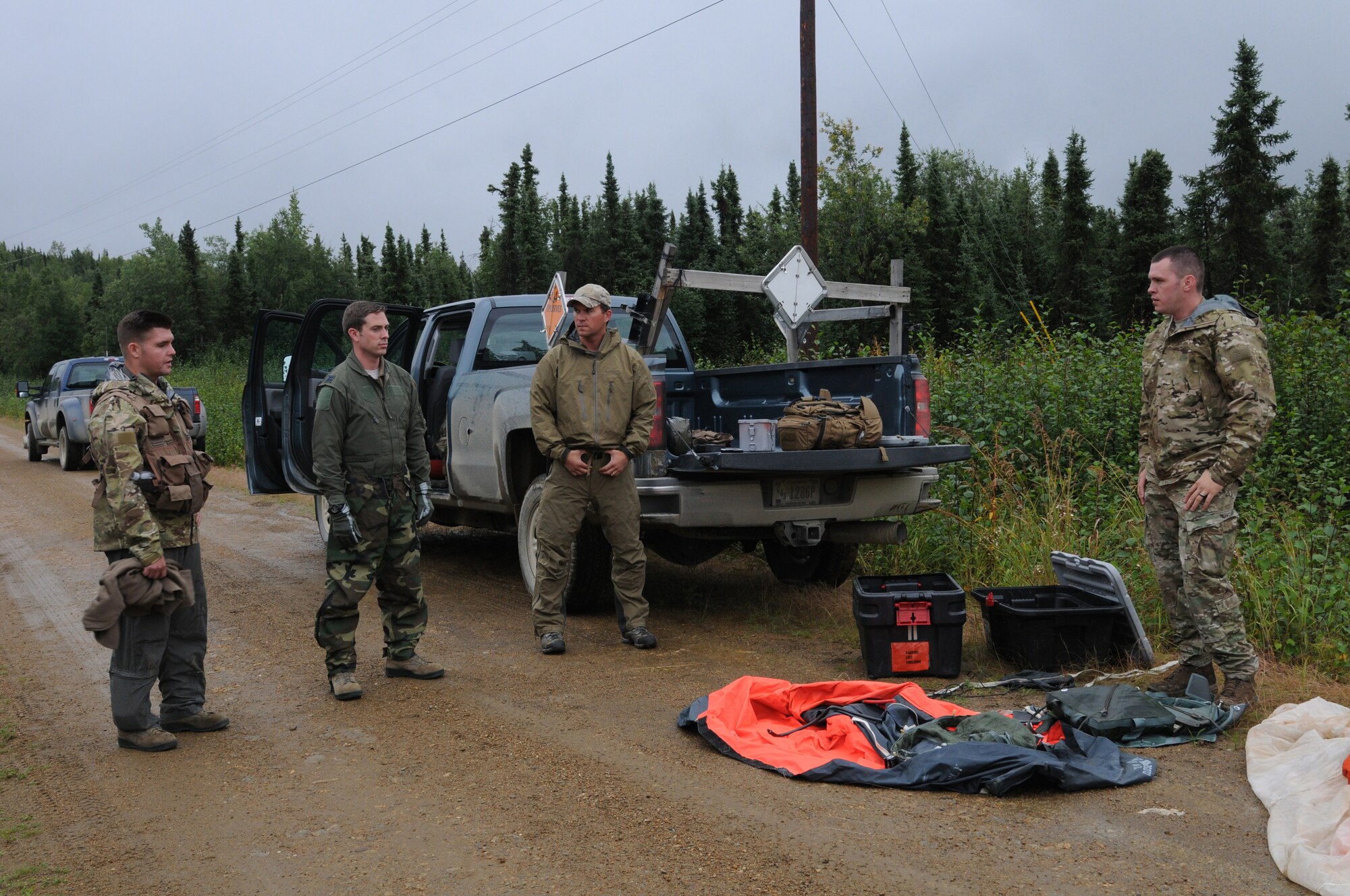 U.S. Air Force survival, evasion, resistance and escape specialists Senior Airman Robert Bowler from the Alaska Air National Guard's 212th Rescue Squadron, and Staff Sgt. Levi Wood from the 353rd Combat Training Squadron at Eielson Air Force Base, Alaska, discuss radio procedures with Capt. Skyler Villers, a pilot from the 36th Fighter Squadron, Republic of Korea, and Capt. Austin Cox, a Minnesota Air National Guard pilot with the 148th Fighter Wing, during an isolated personnel recovery exercise Aug. 13, 2015, at Eielson AFB as part of RED FLAG-Alaska (RF-A) 15-3.  RF-A is a Pacific Air Forces commander-directed field training exercise for U.S. and partner nation forces, providing combined offensive counter-air, interdiction, close air support and large force employment training in a simulated combat environment.  (U.S. Air Force photo by Master Sgt. Ralph Kapustka/Released)