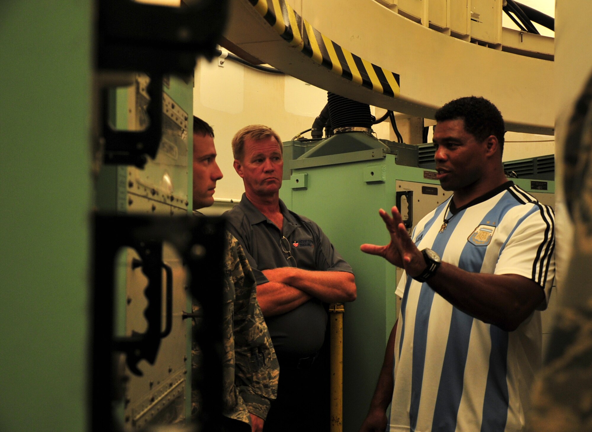 Herschel Walker receives a breakdown of the inside of a missile trainer during his visit to Minot Air Force Base, N.D., Aug. 19, 2015. Walker visited the base to share his message of resiliency and how he overcame his hardships to be the man he is today. Walker is a retired professional football player and while at the University of Georgia, was awarded the Heisman Trophy in 1982.  (U.S. Air Force photo/Staff Sgt. Malia Jenkins)