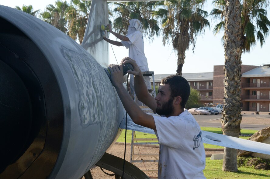 James Bridges and Hayden Yager, civilian contractors, use sandblasters to prepare sections of the F-104C Starfighter static display for painting at Luke Air Force Base, Arizona, Aug. 13, 2015. The F-104C Starfighter was an aircraft that was used to train German pilots in the 1950s. (U.S. Air Force photo by Senior Airman James Hensley)