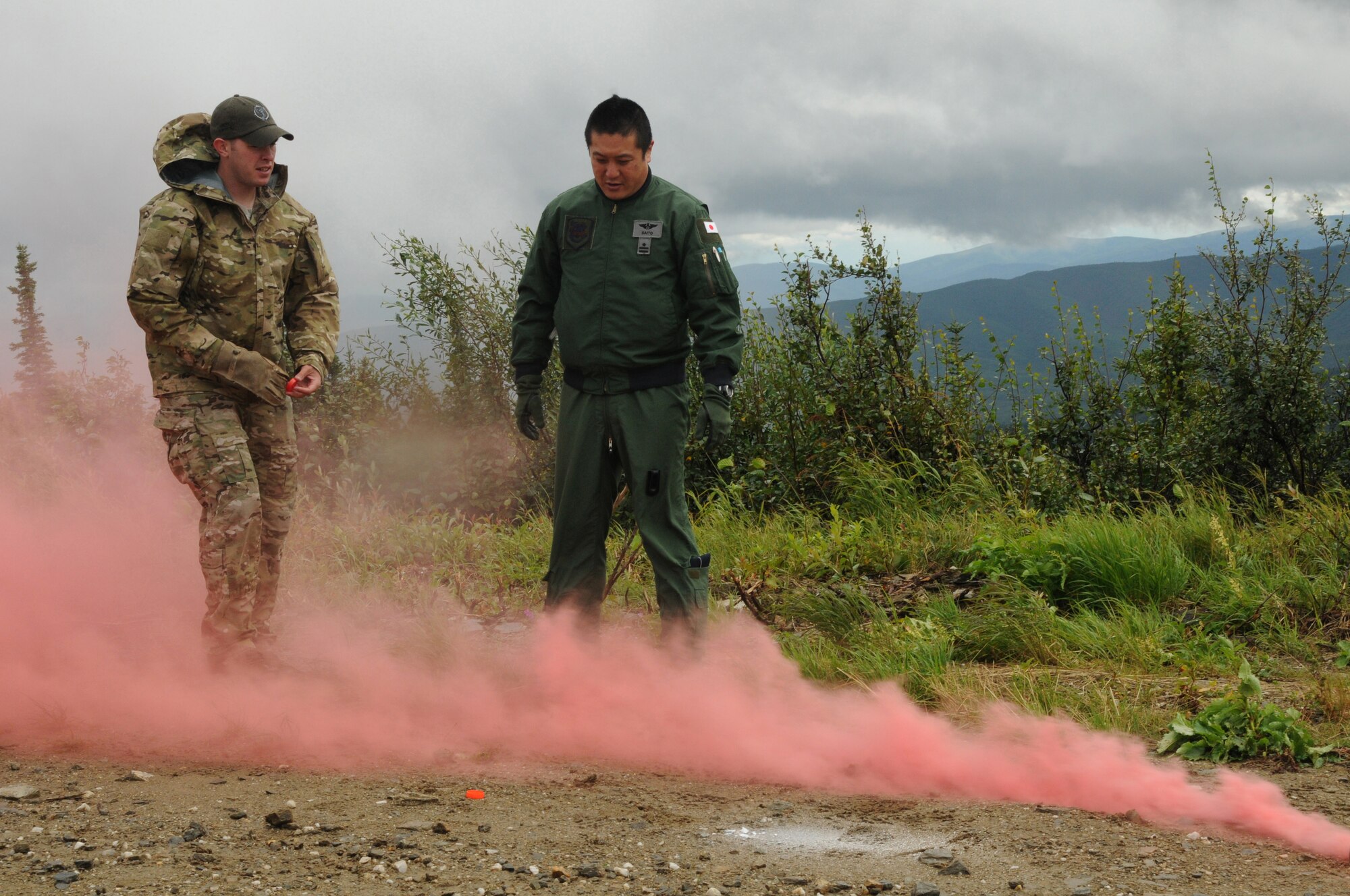 U.S. Air Force Staff Sgt. Levi Wood, a survival, evasion, resistance and escape specialist with the 353rd Combat Training Squadron, and Japan Air Self-Defense Force Maj. Tomohiro Saito, a pilot with the Air Rescue Wing, discuss rescue equipment during an immediate shoot-down exercise Aug. 12, 2015, at Eielson Air Force Base, Alaska, as part of RED FLAG-Alaska (RF-A) 15-3.  RF-A is a Pacific Air Forces commander-directed field training exercise for U.S. and partner nation forces, providing combined offensive counter-air, interdiction, close air support and large force employment training in a simulated combat environment.  (U.S. Air Force photo by Master Sgt. Ralph Kapustka/Released)