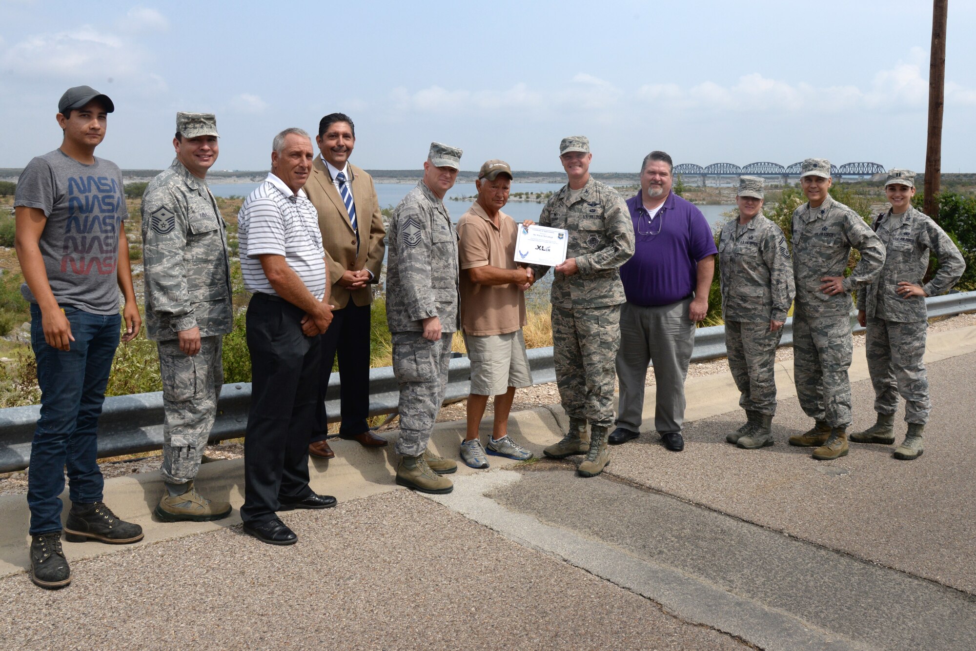 Wayne McCullogh, center, 47th Force Support Squadron marine engine mechanic, poses with Col. Thomas Shank, 47th Flying Training Wing commander, and Chief Master Sgt. Grantland Rice, 47th Operation Group superintendent, after accepting the “XLer of the Week” award, here, August 20, 2015. The “XLer” is a weekly award chosen by wing leadership and is presented to those who consistently make outstanding contributions to their unit and Laughlin. (U.S. Air Force photo by Airman 1st Class Brandon May)