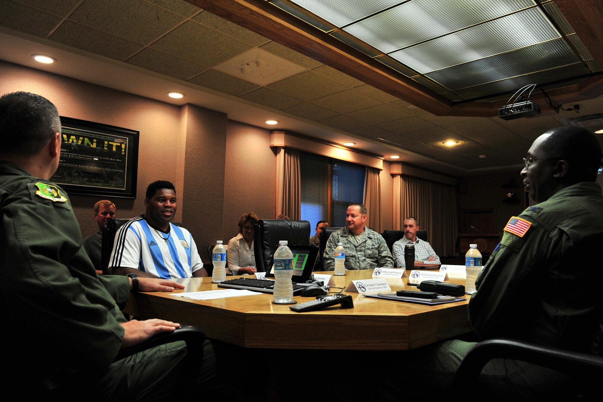 Team Minot Leadership explains the base’s mission to Herschel Walker during his visit to Minot Air Force Base, N.D., Aug. 19, 2015. Walker visited the base to share his message of resiliency and how he overcame his hardships to be the man he is today. Walker is a retired professional football player and while at the University of Georgia, was awarded the Heisman Trophy in 1982. (U.S. Air Force photo/Staff Sgt. Malia Jenkins)