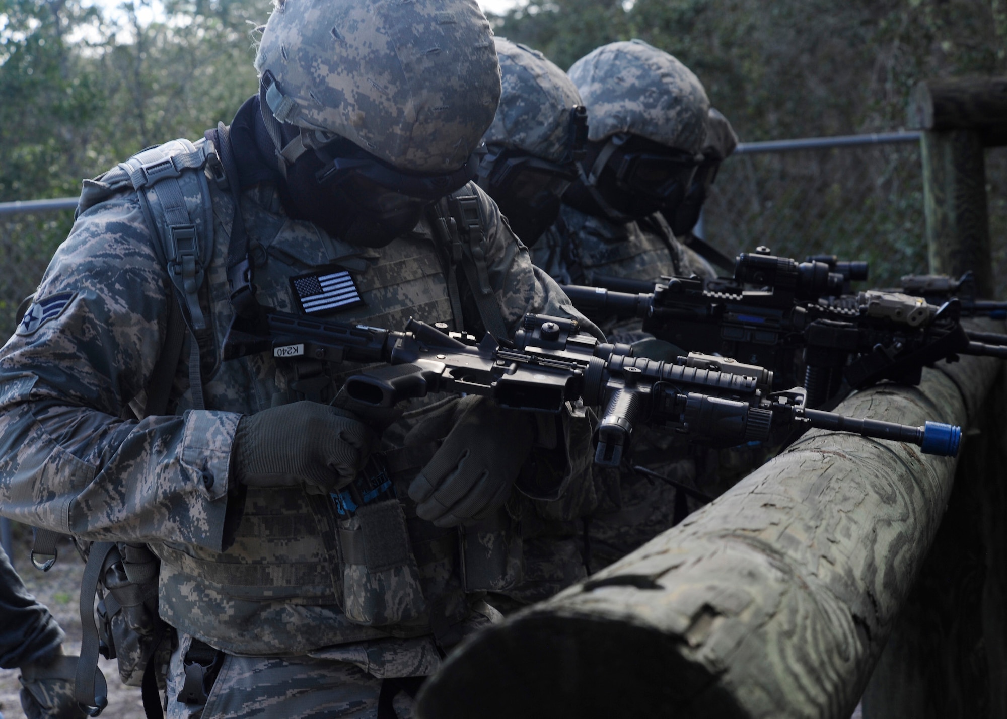 A team of 325th Security Forces Squadron members perform a final operational check of their training rifles before an exercise Aug. 18 in preparation of a Shoot, Move and Communicate exercise with emphasize on self-aid and buddy care under fire. The purpose of the exercise was to maintain certifications and give Airmen experience in SABC in a simulated combat area. (U.S. Air Force photo by Airman 1st Class Solomon Cook/Released)