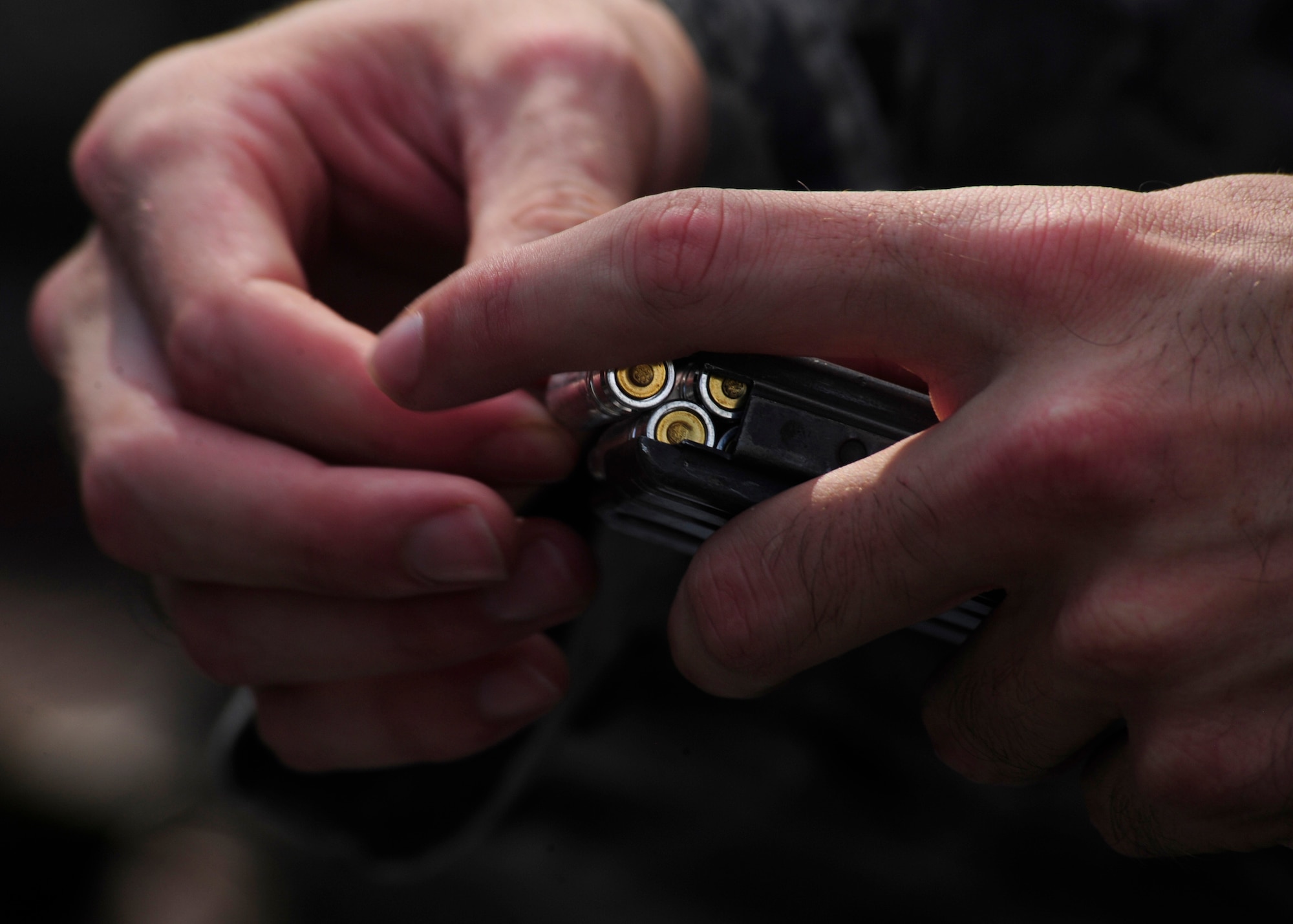 A 325th Security Forces Squadron member loads simulated ammunition to a rifle magazine Aug. 18 in preparation of a Shoot, Move and Communicate exercise with emphasize on self-aid and buddy care under fire. The purpose of the exercise was to maintain certifications and give Airmen experience in SABC in a simulated combat area. (U.S. Air Force photo by Airman 1st Class Solomon Cook/Released) 