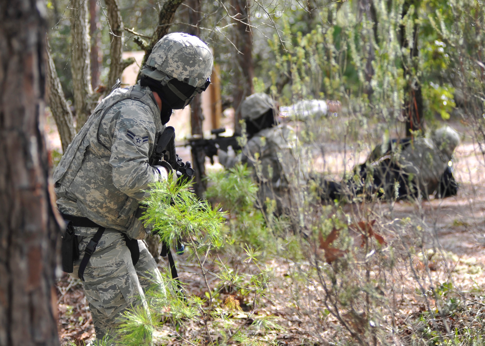 Airman 1st Class Justin Osinga, 325th Security Force Squadron response force member, covers his team during a Shoot, Move and Communicate exercise Aug. 18. The purpose of the exercise was to maintain certifications and give Airmen experience in self-aid buddy care in a simulated combat area.  (U.S. Air Force photo by Airman 1st Class Sergio A. Gamboa/Released)