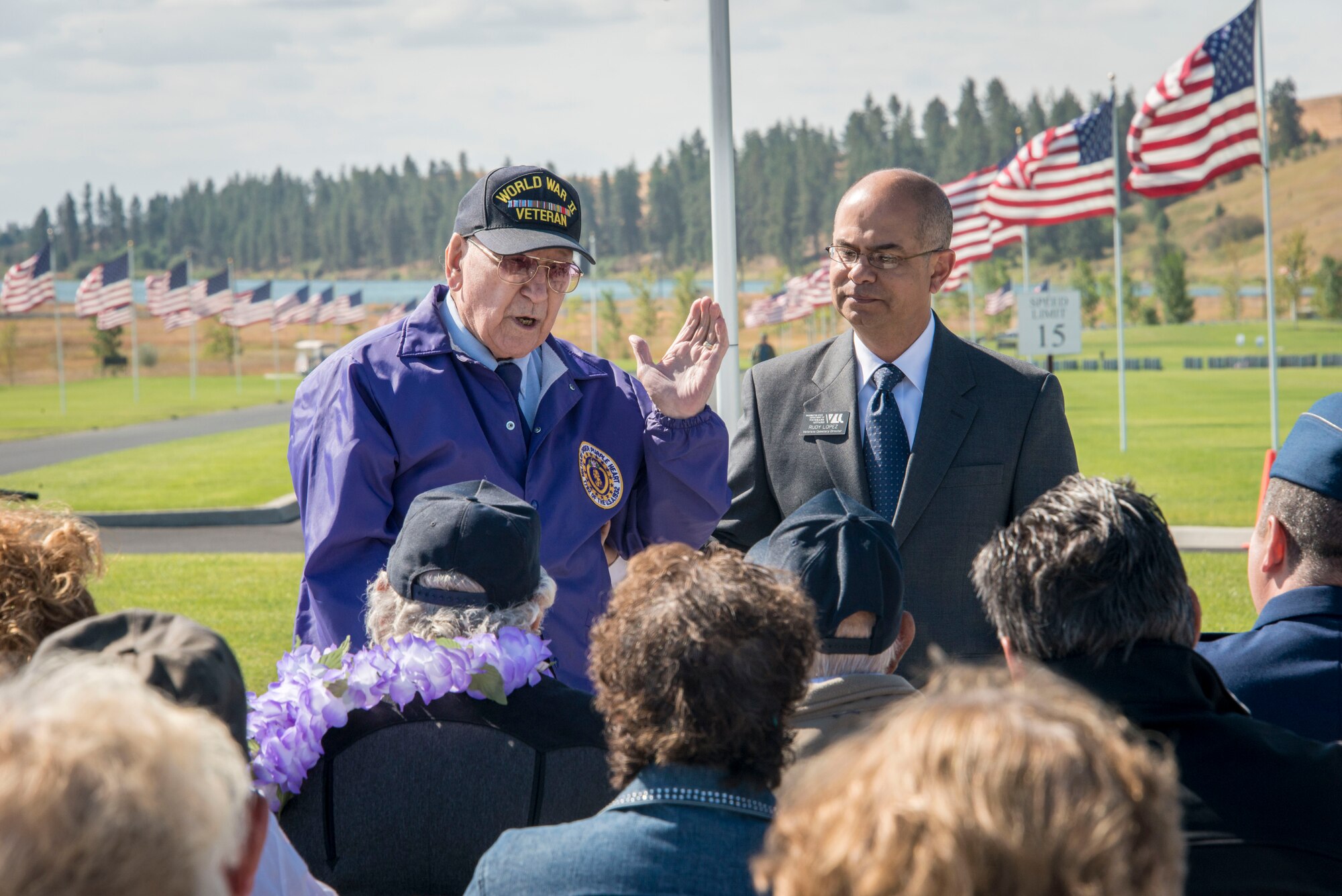 U.S. Army Cpl. Harry Goedde, WWII European Theater frontline soldier and Purple Heart recipient from the Battle of the Bulge, flanked by Rudy Lopez, Medical Lake Washington State Veterans Cemetery director and retired Air Force chief master sergeant, talks with fellow World War II veterans and others in attendance during the commemoration ceremony for the 70th anniversary to the end of World War II Aug. 15, 2015, at the Washington State Veterans Cemetery in Medical Lake, Wash. Goedde talked about his experience in the war and the incredible friendships he and his fellow service members made while pioneering American military innovation. (U.S. Air Force photo/Staff Sgt. Benjamin W. Stratton)
