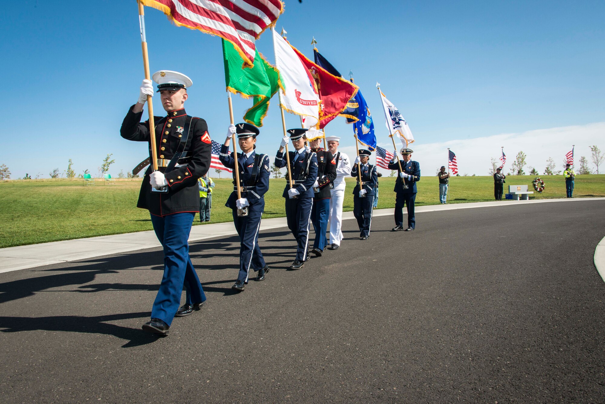 Multi-service color guard marches away following the kickoff of the commemoration ceremony for the 70th anniversary to the end of World War II Aug. 15, 2015, at the Washington State Veterans Cemetery in Medical Lake, Wash. Color guards present the national flag and other flags appropriate to its position in the chain of command. In addition to the flag bearers, who are positioned in the center of the color guard, there are two or more individuals who carry rifles and or sabers in a typical formation. (U.S. Air Force photo/Staff Sgt. Benjamin W. Stratton)