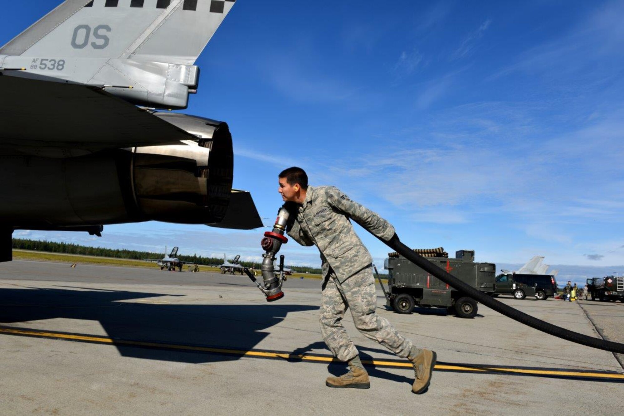 U.S. Air Force Senior Airman Sean Cummings, a 92nd Logistics Readiness Squadron fuels distribution apprentice carries a fuel hose out to the crew chief of an F-16 Fighting Falcon assigned to the Minnesota Air National Guard’s 148th Fighter Wing out of Duluth, Minn., on the Eielson Air Force Base, Alaska, flightline Aug. 14, 2015, during RED FLAG-Alaska (RF-A) 15-3. RF-A is a Pacific Air Forces commander-directed field training exercise for U.S. and partner nation forces, providing combined offensive, counter-air, interdiction, close-air support, and large-force employment training in a simulated combat environment. (U.S. Air Force photo by Airman 1st Class Kyle Johnson)