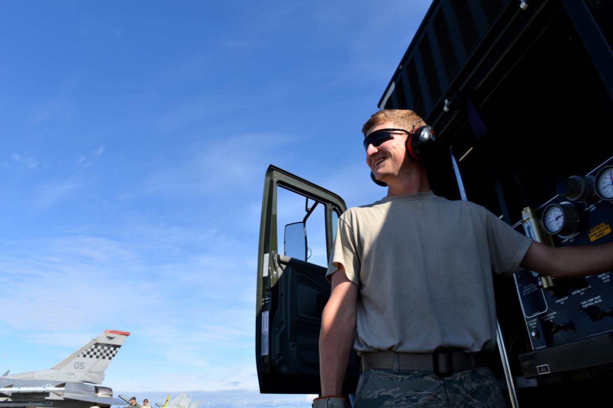 U.S. Air Force Senior Airman Tyler Wakefield, a 354th Logistics Readiness Squadron distribution operator, smiles as he flips a switch on an R-11 Refueler at the Eielson Air Force Base, Alaska, flightline Aug. 14, 2015 during RED FLAG-Alaska (RF-A) 15-3. RF-A is a Pacific Air Forces commander-directed field training exercise for U.S. and partner nation forces, providing combined offensive, counter-air, interdiction, close-air support, and large-force employment training in a simulated combat environment. (U.S. Air Force photo by Airman 1st Class Kyle Johnson)