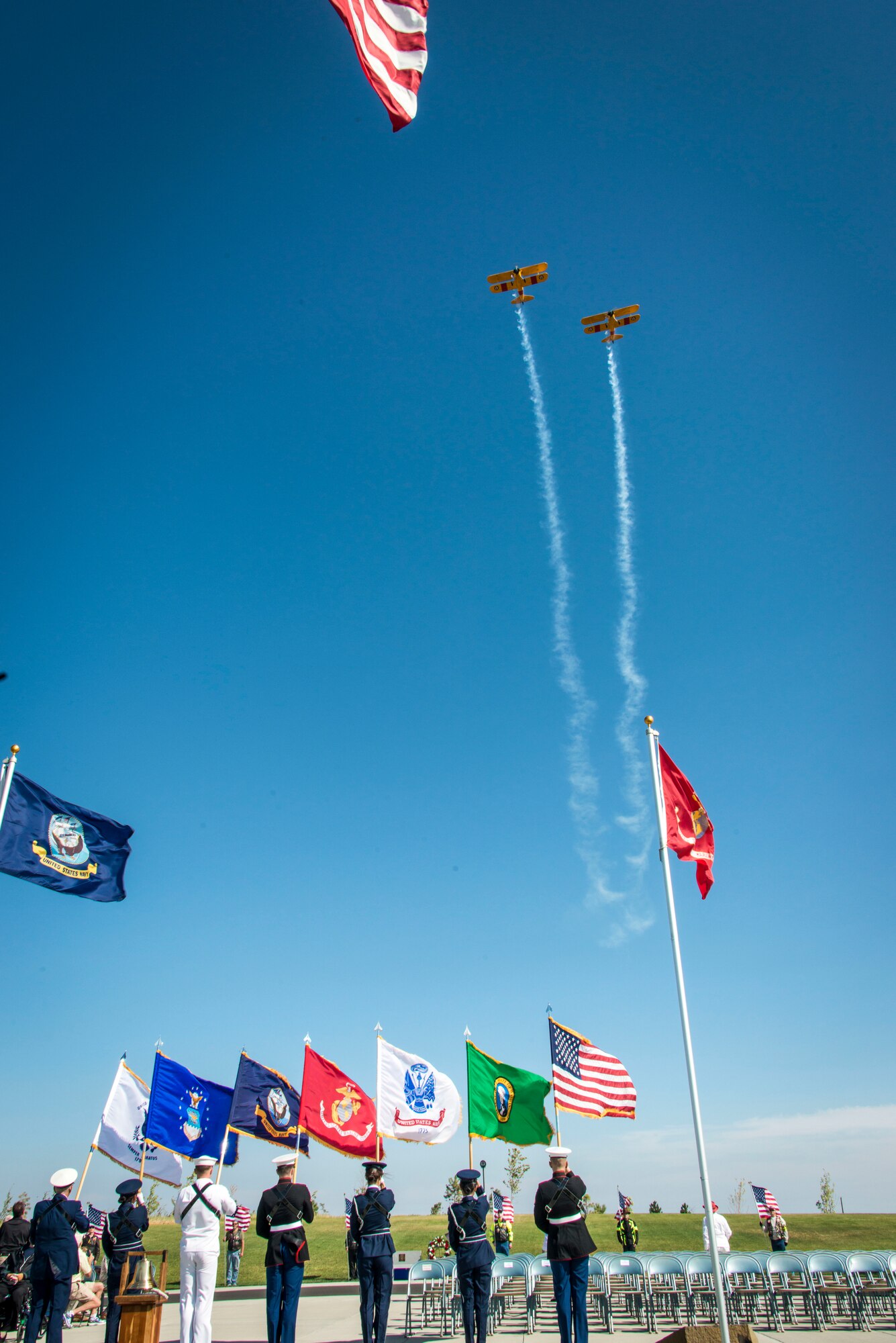 Two Boeing-Stearman Model 75 biplane trainers fly overhead as a multi-service honor guard presents the colors kicking off the commemoration ceremony for the 70th anniversary to the end of World War II Aug. 15, 2015, at the Washington State Veterans Cemetery in Medical Lake, Wash. The ceremony was part of a nationwide observance called the “Spirit of ‘45” aimed at ensuring present and future generations never forget the sacrifices and victories accomplished by the “Greatest Generation.” (U.S. Air Force photo/Staff Sgt. Benjamin W. Stratton)