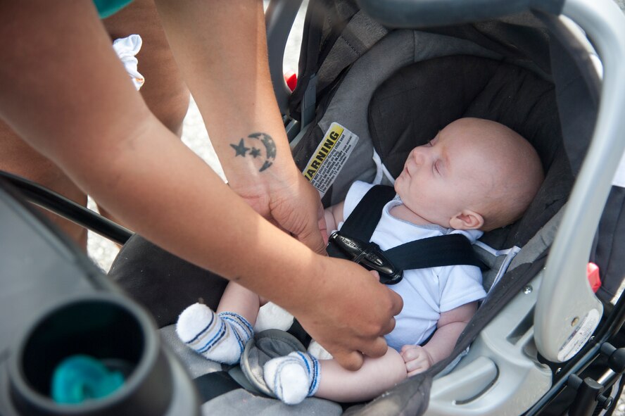 Shannon Power, certified car seat technician,  potions, uses a rolled-up diaper to help safely secure a 2-month-old child in his car seat Aug. 18, 2015, at the  Child Development Center on Dover Air Force Base, Del. For rear facing car seats, the harness should be at or below the child’s shoulders; for smaller children the use of a rolled-up receiving blanket or diaper between the crotch of the car seat and newborn can be used to help them stay properly positioned in the seat. (U.S. Air Force photo/Senior Airman Jared Duhon)