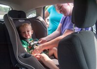 Nichole McDannell, 436th Aerospace Medicine Squadron, buckles her son, Max, into his car seat Aug. 18, 2015, at the Child Development Center on Dover Air Force Base, Del. Children in forward facing car seats should have straps at or above the child’s shoulders and once secured, there should be no slack if pinched and the chest clips should be located at the armpits. (U.S. Air Force photo/Senior Airman Jared Duhon) 