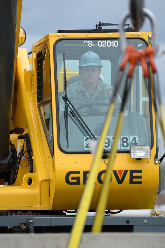 Staff Sgt. Jacob Backer, of the 119th Civil Engineer Squadron, maneuvers a concrete barrier into a target area using a crane as he trains at the North Dakota Air National Guard Regional Training Site, Fargo, North Dakota, August 19, 2015. The North Dakota Air National Guard Regional Training Site is one of five contingency training locations in the United States used by Air National Guard and U.S. Air Force personnel in the civil engineer career fields. I provides wartime mission training as well as proficiency training on construction practices, utility support, emergency services, maintenance and repair of base infrastructure. Four separate groups totaling about 400 people are scheduled to train at the site in the month of August in 2015. (U.S. Air National Guard photo by Senior Master Sgt. David H. Lipp/Released)