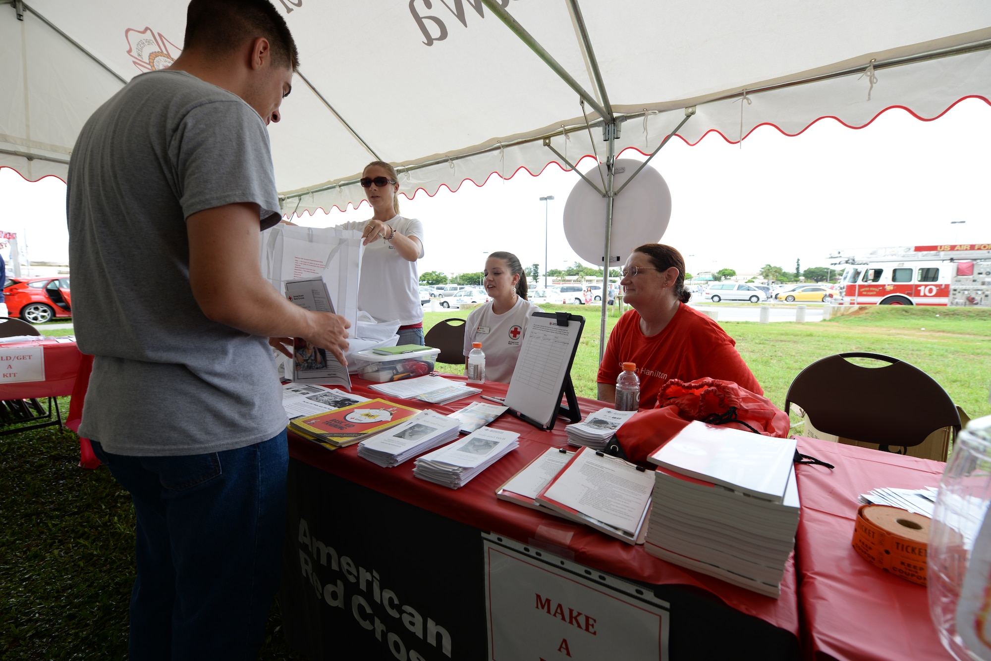 Volunteers from the Red Cross brief a passerby on typhoon and emergency preparedness during the Typhoon Preparedness Extravaganza on Kadena Air Base, Japan, Aug. 15, 2015. The event’s goal was to get newcomers on Okinawa to get informed, have a plan and build a kit for typhoons. (U.S. Air Force photo by Senior Airman Omari Bernard))