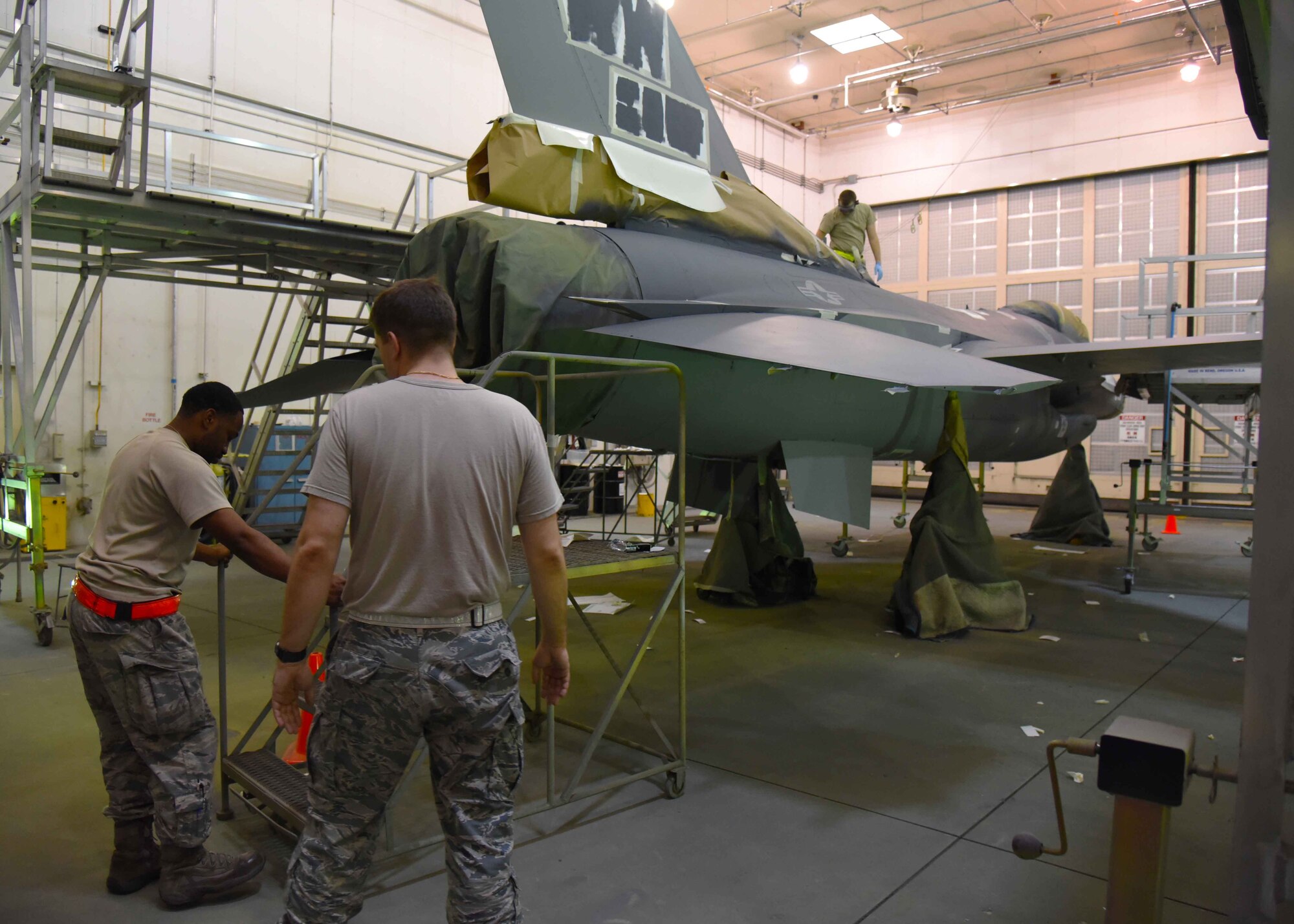 Airmen from the 35th Maintenance Squadron aircraft structural maintenance flight paint the body of an F-16 Fighting Falcon at Misawa Air Base, Japan, Aug. 20, 2015. Although their repairs are often different, a full-body paint job is among the many responsibilities of the aircraft structural maintenance flight. The process of painting an aircraft can take up to two weeks. (U.S. Air Force photo by Senior Airman Patrick S. Ciccarone/Released)