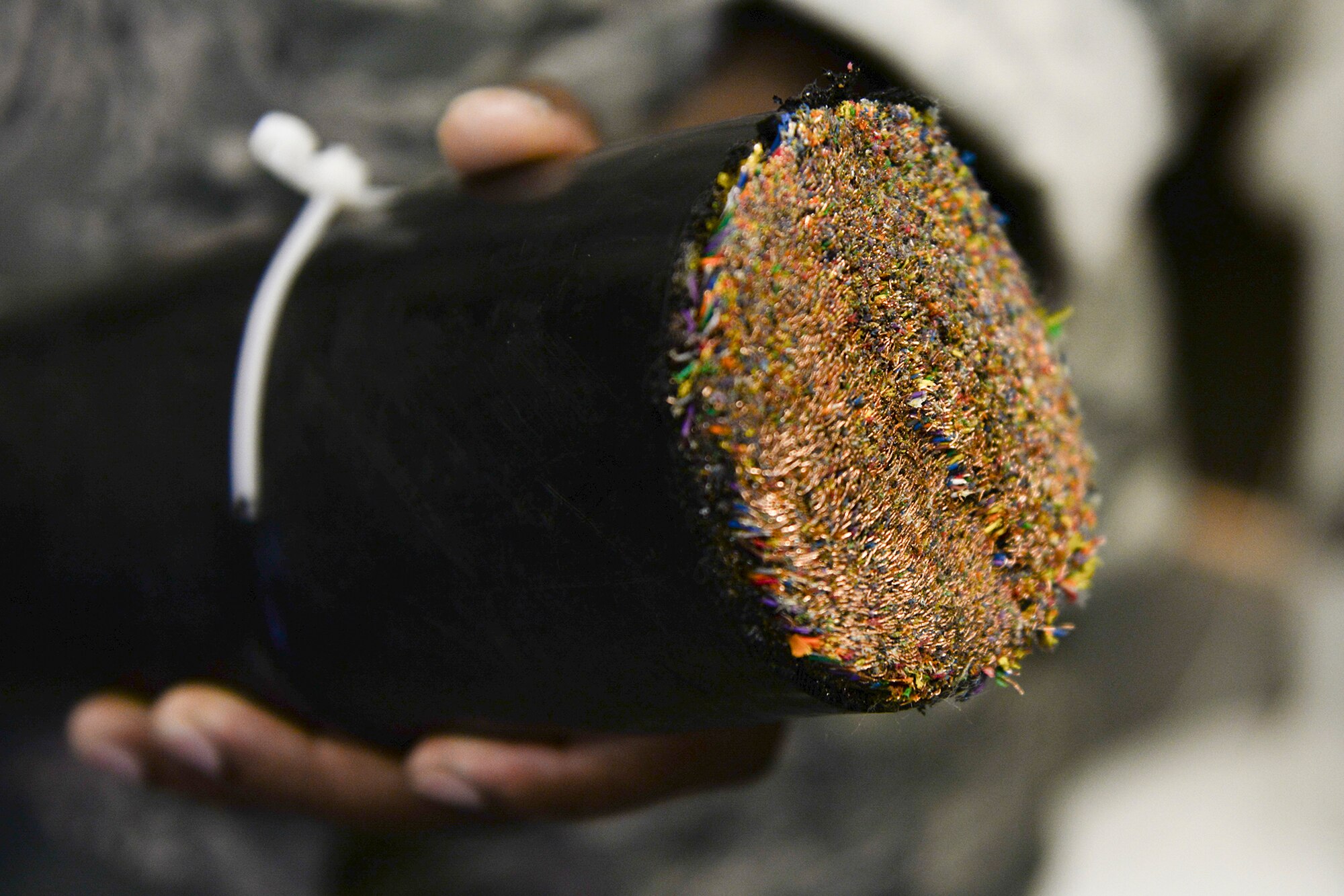 A 374th Communications Squadron Airman displays a cable containing 3,600 copper wires at Yokota Air Base, Japan, Aug. 19, 2015. During a splice, each wire has to be connected to the appropriate corresponding wire on the other cable. (U.S. Air Force photo by Airman 1st Class Elizabeth Baker/Released)