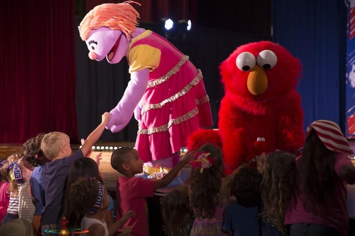 Katie and Elmo greet children at the Sesame Street performance delivered by the United Services Organization Experience for Military Families at the Sakura Theater aboard Marine Corps Air Station Iwakuni, Japan, Aug. 14, 2015. The program, “Katie is Moving to a New Base,” is designed to help children of military families transition during a permanent change of station. Military kids may relate to Katie’s situation and could learn how to deal with a difficult move away from family and friends.