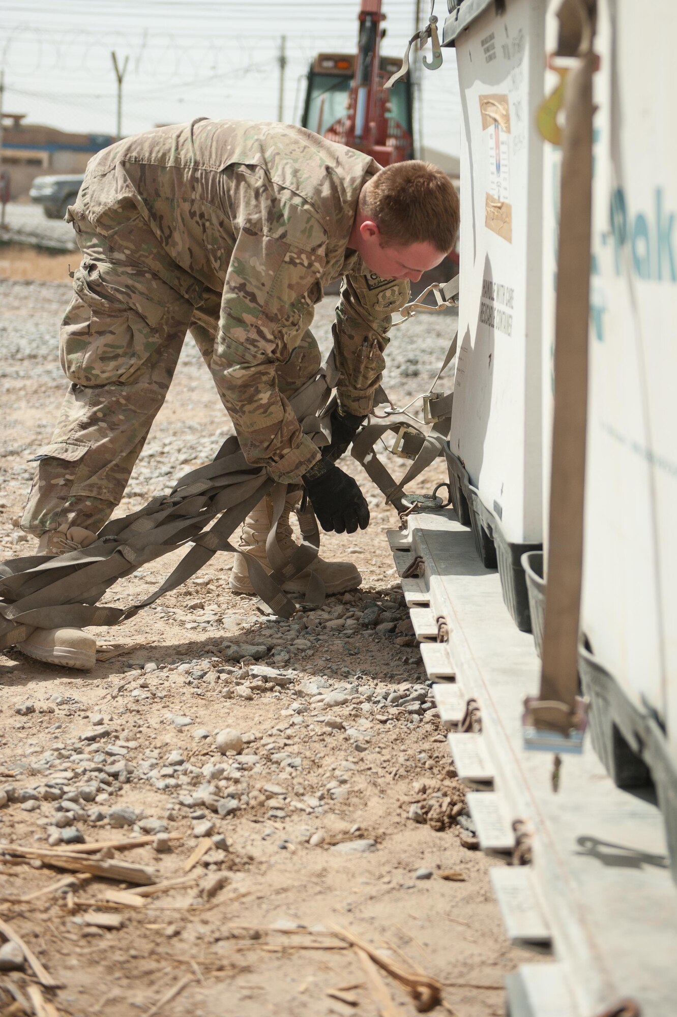 U.S. Air Force Staff Sgt. Cody Madison, 451st Expeditionary Support Squadron Central Command Material Recovery Element joint inspector, removes cargo straps from a pallet at Kandahar Airfield, Aug. 15, 2015. Madison is responsible for identifying, storing and redeploying assets to the U.S. or disposing of items located throughout Afghanistan. (U.S. Air Force photo by Tech. Sgt. Joseph Swafford/Released)