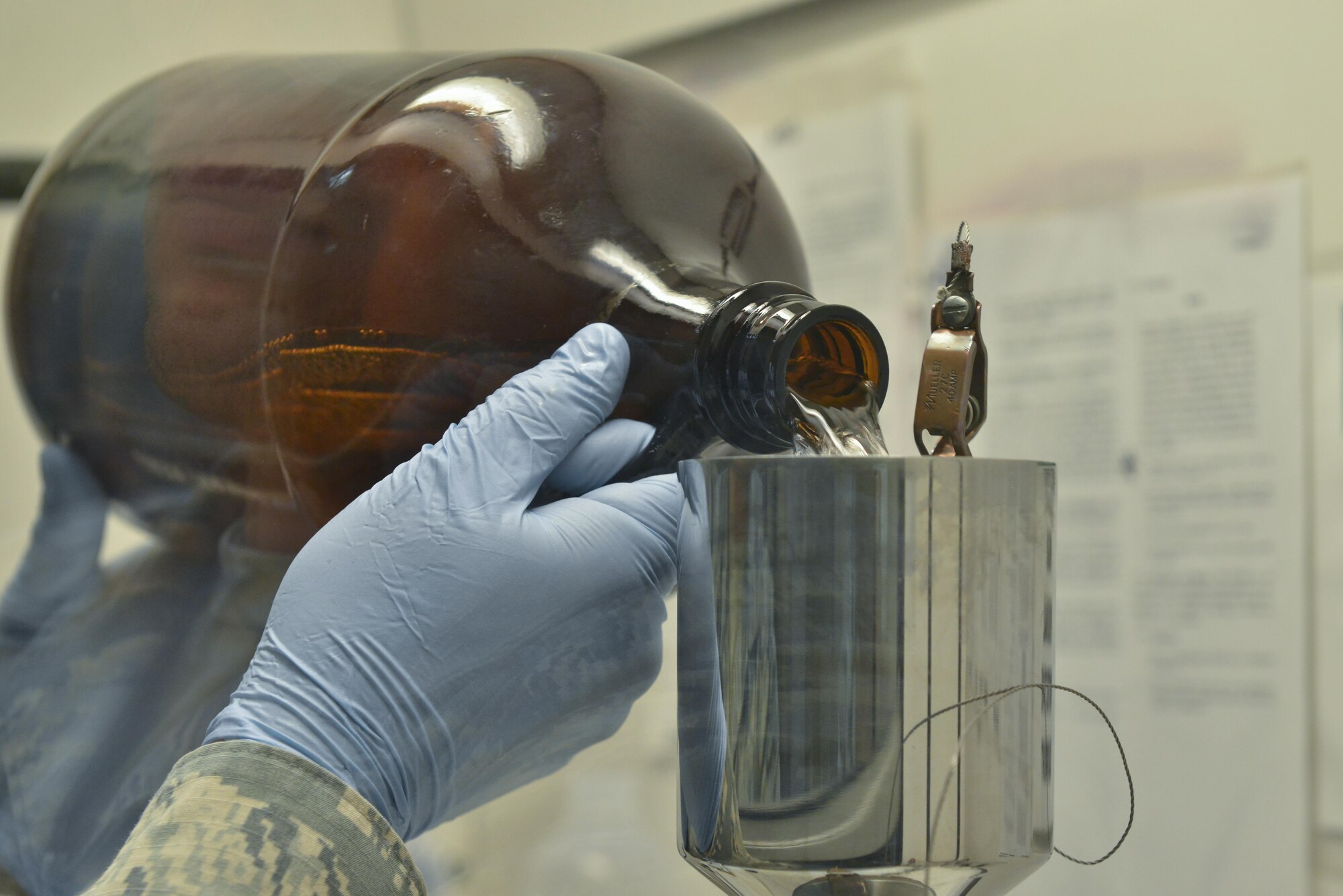 Staff Sgt. David Ramirez, 379th Expeditionary Logistic Readiness fuels laboratory, pours jet petroleum 8 through a funnel that will filter the fuels to test for particles August 18, 2015 at Al Udeid Air Base, Qatar. The base fuels laboratory at Al Udeid tests all petroleum that is used in aircraft, vehicles and generators throughout the installation to safeguard its quality, performance and safety. (U.S. Air Force photo/ Staff Sgt. Alexandre Montes)