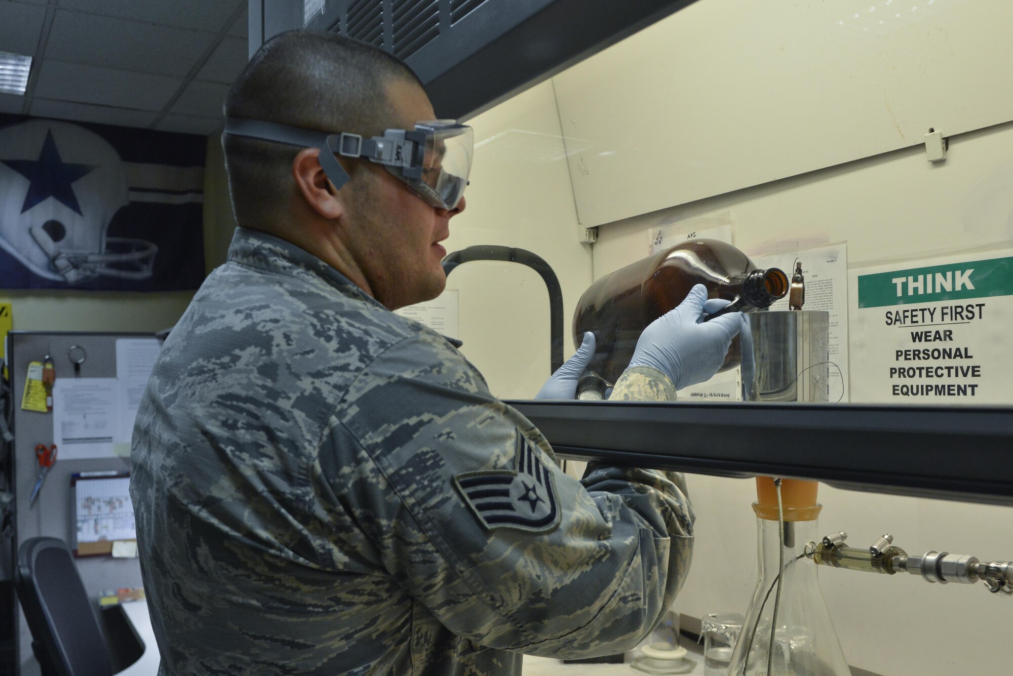 Staff Sgt. David Ramirez, 379th Expeditionary Logistic Readiness fuels laboratory, pours jet petroleum 8 through a funnel that will filter the fuels to test for particles August 18, 2015 at Al Udeid Air Base, Qatar. The base fuels laboratory at Al Udeid tests all petroleum that is used in aircrafts, vehicles and generators throughout the installation to safeguard its quality, performance and safety. (U.S. Air Force photo/ Staff Sgt. Alexandre Montes)