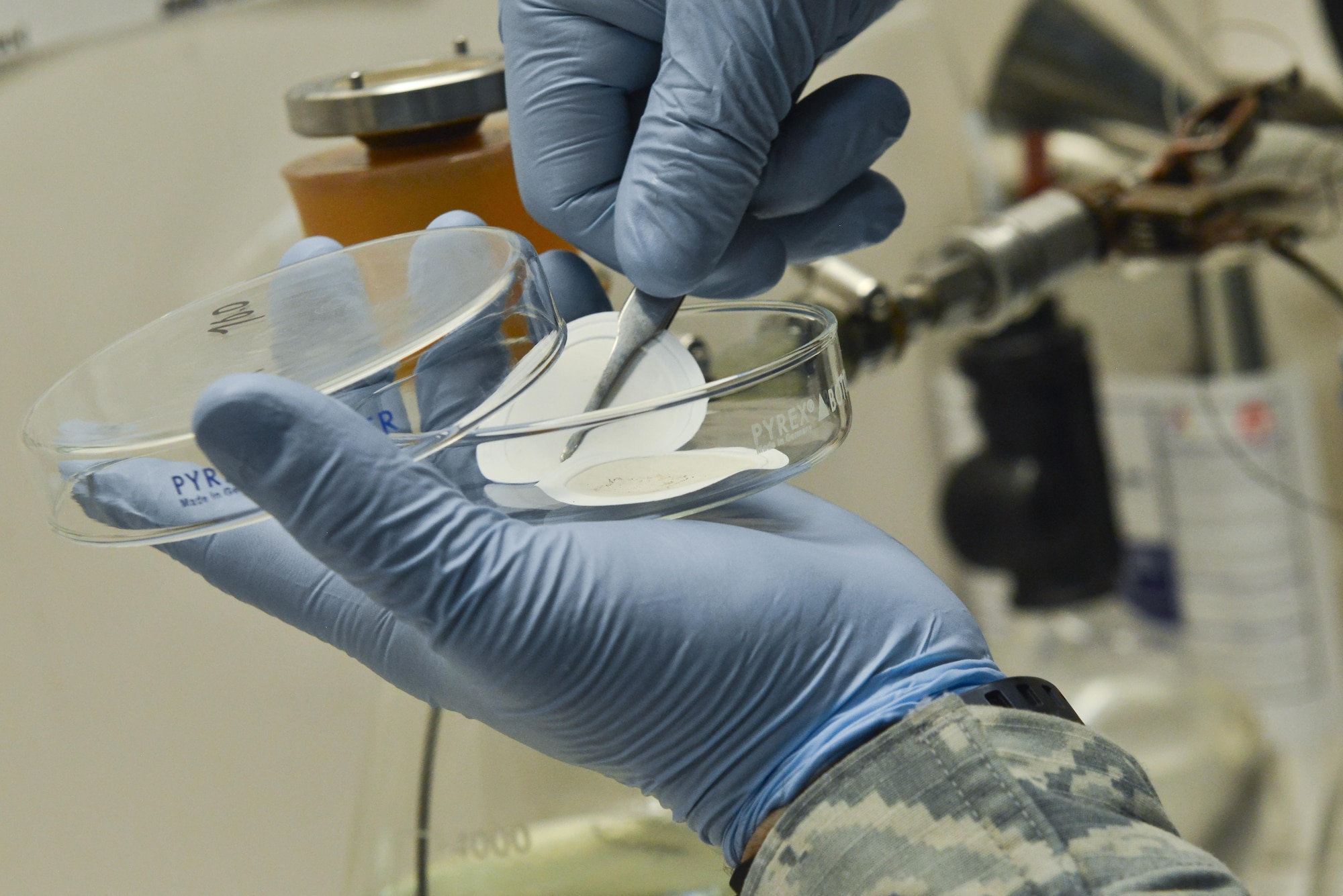 Staff Sgt. David Ramirez, 379th Expeditionary Logistic Readiness fuels laboratory, removes two filters that help separate any debris that is caught in the fuel during routine testing August 18, 2015 at Al Udeid Air Base, Qatar. The base fuels laboratory at Al Udeid tests all petroleum that is used in aircraft, vehicles and generators throughout the installation to safeguard its quality, performance and safety. (U.S. Air Force photo/ Staff Sgt. Alexandre Montes)