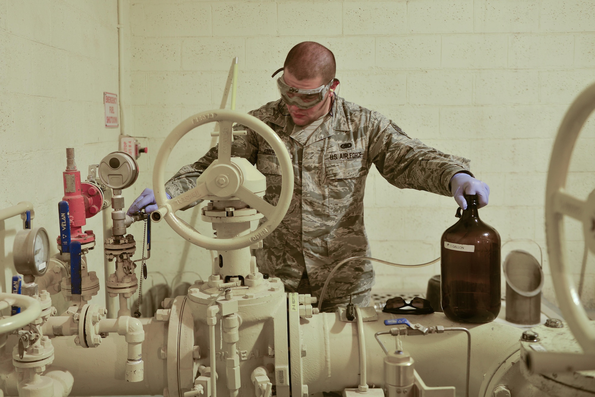 Staff Sgt. David Ramirez, 379th Expeditionary Logistic Readiness fuels laboratory, extracts a sample of jet petroleum 8 from a running pipeline which supplies the aircraft deployed here August 19, 2015 at Al Udeid Air Base, Qatar. The base fuels laboratory at Al Udeid tests all petroleum that is used in aircraft, vehicles and generators throughout the installation to safeguard its quality, performance and safety. (U.S. Air Force photo/ Staff Sgt. Alexandre Montes)