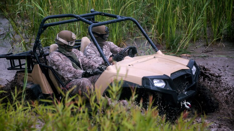 Marines with Force Reconnaissance Platoon, 22nd Marine Expeditionary Unit, drive through a fording pit during an all - terrain vehicle course at Marine Corps Base Camp Lejeune, North Carolina, Aug. 18, 2015. Marines drove the Polaris Rzr tactical vehicles through a water pit to gain experience with vehicle handling in swampy terrain.