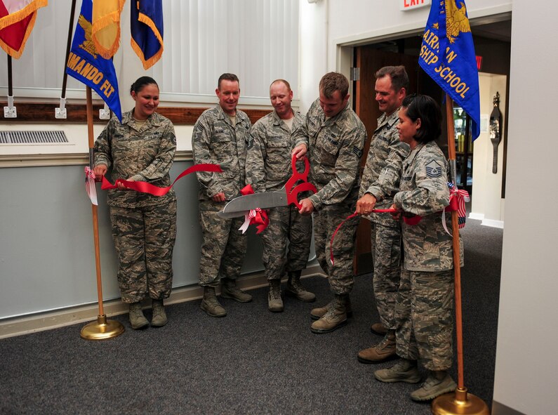 Staff Sgt. Ryan Peters, 823rd Red Horse Squadron structural worker, cuts ribbon with the 1st Special Operations Wing leadership and Airmen Leadership School commandant on Hurlburt Field, Fla., Aug. 17, 2015. The 823rd Red Horse Squadron and the 1st Special Operations Civil Engineering Squadron combined efforts to renovate an auditorium to meet increasing goals for student graduation sizes. (U.S. Air Force photo by Senior Airman Meagan Schutter/Released)