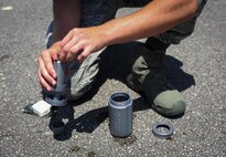 Airman 1st Class Teddy Compston, 1st Special Operations Civil Engineer Squadron explosive ordnance disposal apprentice, packs Composition C-4 into a water bottle before an explosives demonstration on Hurlburt Field, Fla., Aug. 5, 2015. Chaplain candidates had the opportunity to view the effects of explosives, speak with experienced EOD technicians about resiliency and try on bomb suits during their visit. (U.S. Air Force photo/ Senior Airman Meagan Schutter)