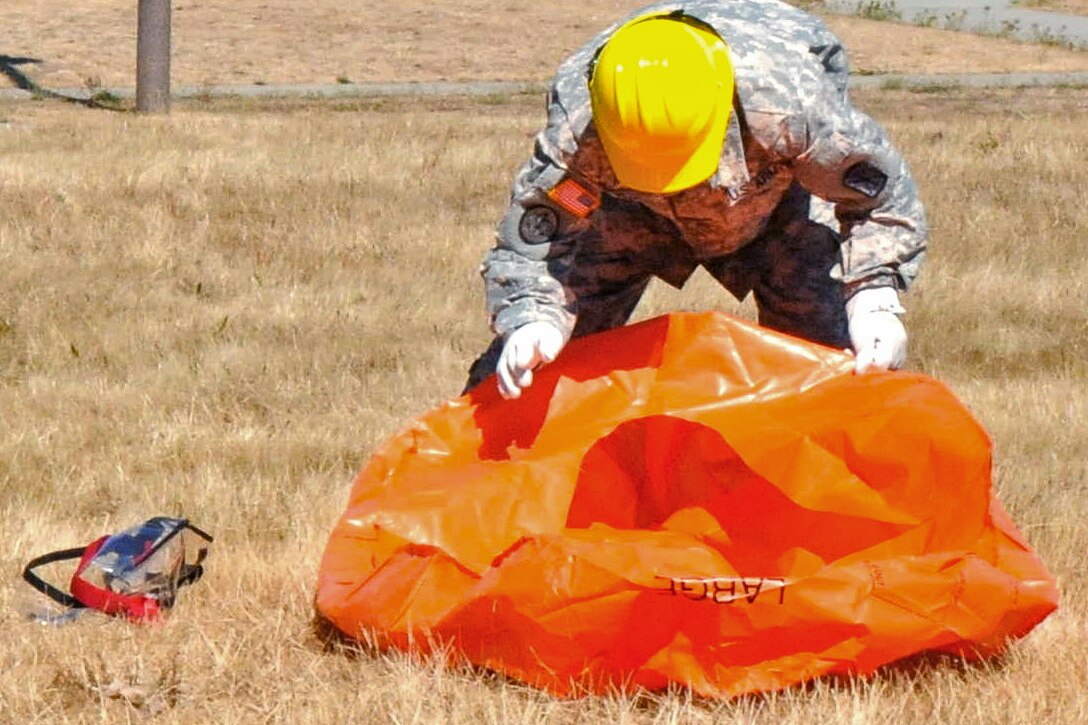 A soldier practices firefighting techniques with his personal protective equipment as 200 soldiers prepare to serve as firefighters to assist the National Interagency Fire Center on Joint Base Lewis-McChord, Wash., Aug. 19, 2015.
