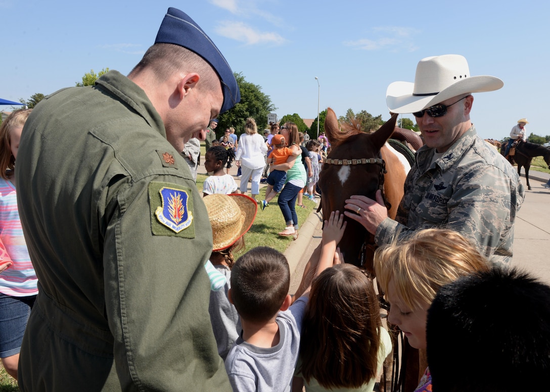U.S. Air Force Col. Todd Hohn, 97th Air Mobility Wing commander, speaks with children during the annual 17th-Annual Altus Air Force Base, Oklahoma, Cattle Drive, Aug. 20, 2015. The cattle are driven approximately 3.5 miles through the base and housing. (U.S. Air Force photo by Airman 1st Class Megan E. Acs) 
