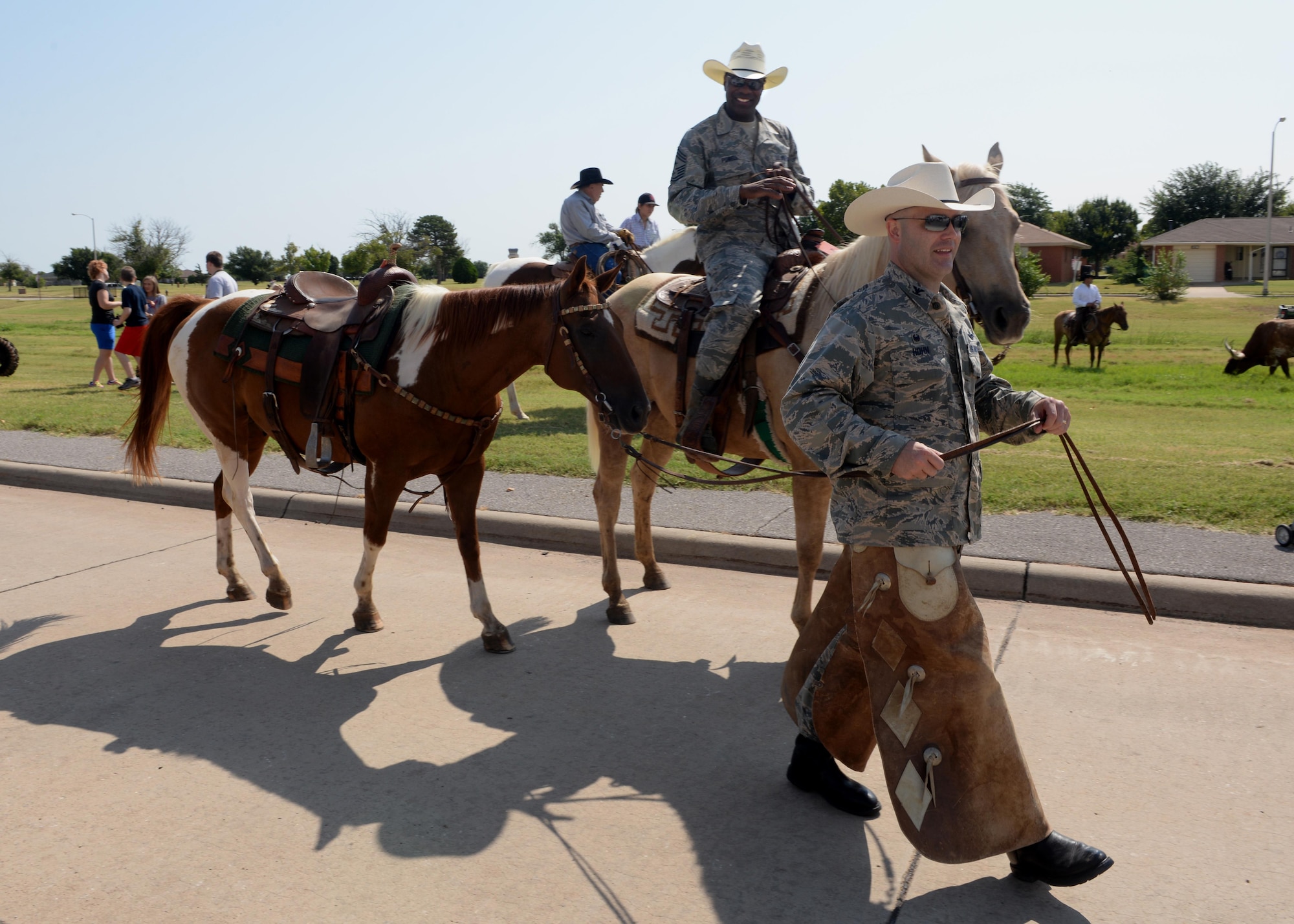 Col. Todd Hohn, 97th Air Mobility Wing commander, and Chief Master Sgt. James Powell III, 97th AMW command chief, participate in the 17th-Annual Altus Air Force Base, Oklahoma, Cattle Drive. The first Altus AFB cattle drive was held in 1999 with 15 riders and a herd of roughly 30 longhorn cattle parading through the streets of Altus AFB and has been a tradition ever since. (U.S. Air Force photo by Airman 1st Class Megan E. Acs) 