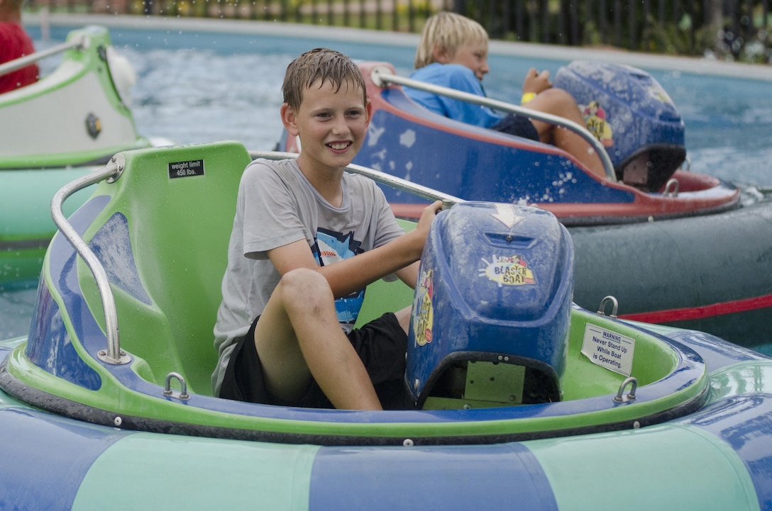 Cavan Garland rides the bumper boats with his friends at Tiki Island near Kaneohe Klipper Golf Course during Klipper Summer Bash 7, Aug. 15, 2015. Marine Corps Community Services Hawaii hosted Klipper Summer Bash 7 at the Kaneohe Klipper Golf Course with a putting and long drive contest, activities, food and entertainment for active duty service members and their families. There were balloon makers, bounce houses, bumper boat rides, mini golf and mini amusement park rides for the children. Live music included Ikena & The Pocket Band, Crimson Apple and The Green. The annual event began in 2009 when the golf course celebrated the completion of its $3 million renovation project. Renovations were done to the pro shop, restaurant, ballroom and driving range. The former Fairways Sports Bar and Grill was renamed Sam Adams Sports Bar and Grill, opening July 29, 2009. Recreational events such as Klipper Summer Bash 7 help boost morale aboard Marine Corps Base Hawaii, furtherin¬g the mission, which is to provide better service for the units, individuals and families in order to enhance and sustain combat readiness for all operating forces and tenant organizations aboard the installation. (U.S. Marine Corps photo by Kristen Wong/Released)   