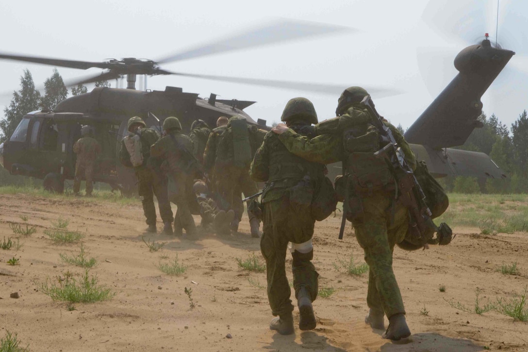 Lithuanian soldiers carry a U.S. soldier who has suffered simulated battlefield injuries toward a waiting UH-60M Black Hawk helicopter during exercise Uhlan Fury at the General Silvestras Zlikaliskas Training Area, Pabrade, Lithuania, Aug. 12, 2015. The training is part of Operation Atlantic Resolve being conducted throughout Europe. The multinational mission strengthens bonds with NATO allies and enhances security in the region. 