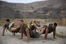 Marines assigned to Company K, 3rd Battalion, 5th Marine Regiment, 1st Marine Division, work together to complete fire team pushups as part of the Dark Horse Ajax Challenge aboard Marine Corps Base Camp Pendleton, Aug. 20, 2015. The eight-mile course tested the Marines’ and Sailors’ endurance and leadership skills with trials spread across the San Mateo area. (U.S. Marine Corps photo by Cpl. Will Perkins)